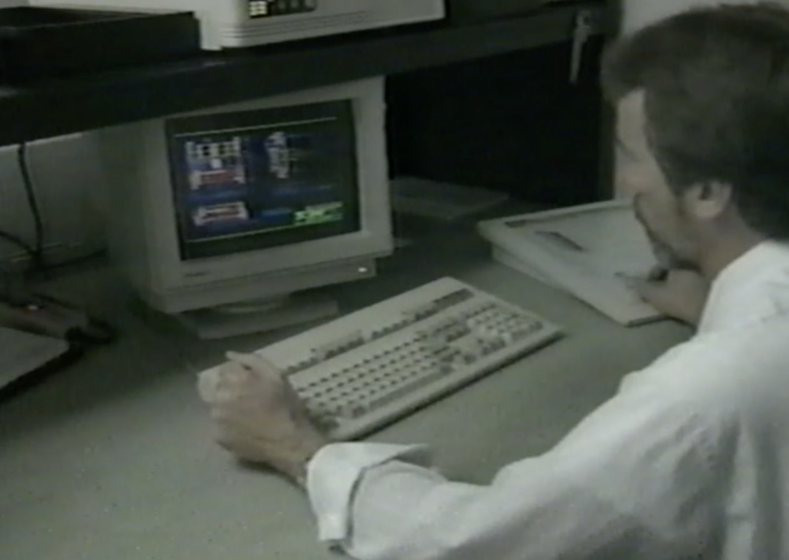 Old VHS image of Zenar employee on a computer